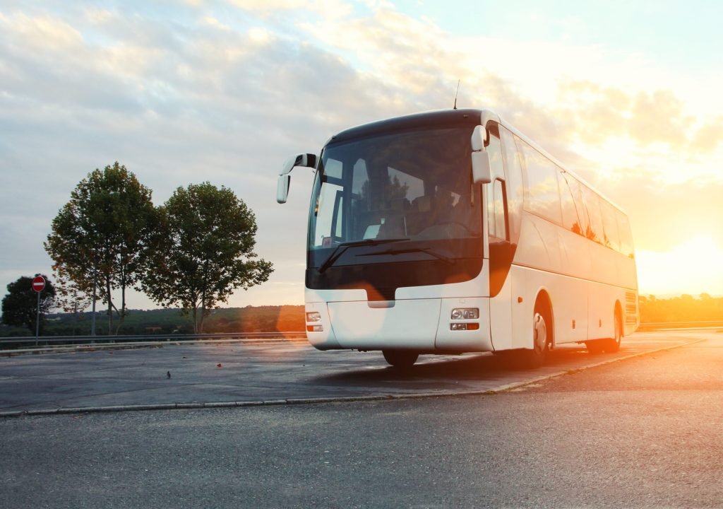 Passenger Bus parked on the road at sunrise.